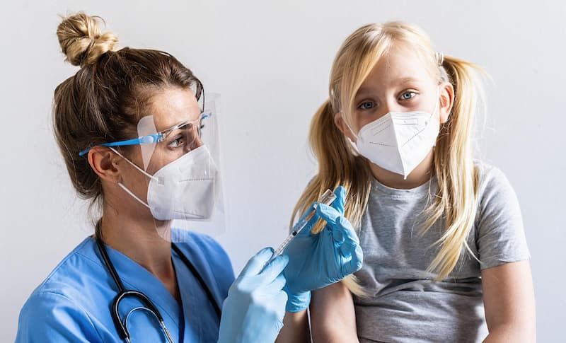 blonde-girl-with-face-mask-looks-camera-vaccination-center-get-vaccinated-syringe-with-vaccine-covid19-coronavirus-flu-dangerous-infectious-diseases (1)